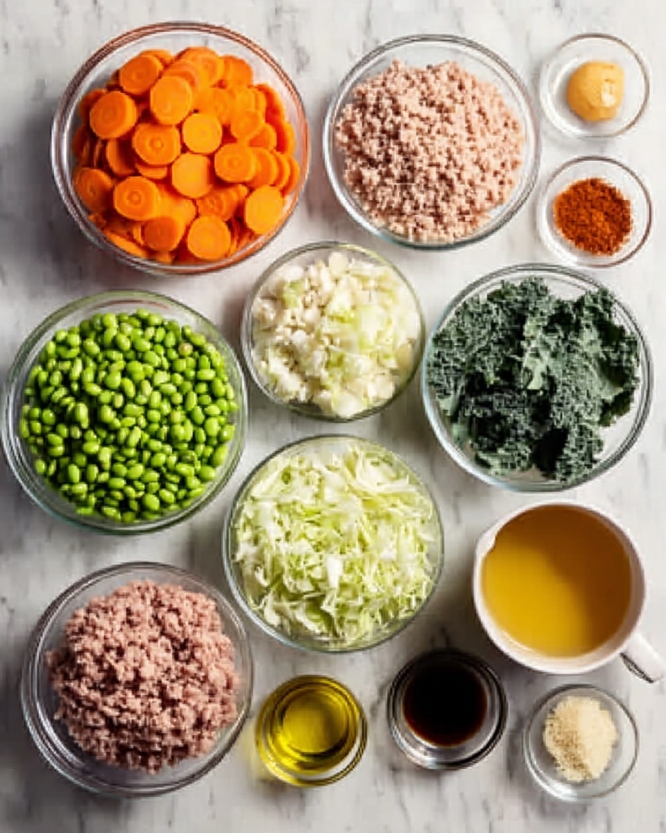 The image shows several clear glass bowls arranged on a white marbled surface. Each bowl contains a different ingredient: bright orange carrot slices, green edamame beans, white grains of rice, minced pink ground meat, pale raw egg, chopped white onion, small light beige beans, shredded pale green cabbage, dark green leafy kale, a small bowl with a reddish-brown powder, a small bowl with what looks like a light yellow spice, and a cup filled with light brown broth. Alongside them, there is a small glass container of yellow oil and a small dark cup of soy sauce. The bowls are neatly spaced, creating a colorful and fresh arrangement. photo taken with an iphone --ar 4:5 --v 7