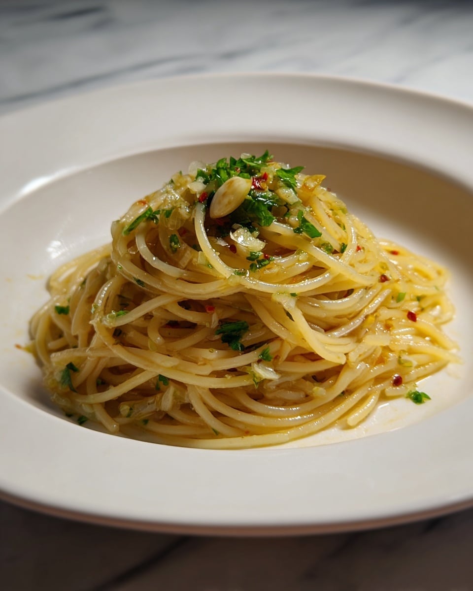 A large shallow silver bowl holds a dish with long, thin spaghetti noodles at the base, light yellow in color with a soft texture. Mixed throughout the noodles are cooked green spinach leaves scattered evenly, adding a fresh green color. On top of the noodles and spinach are cut slices of pink cooked sausage placed unevenly across the dish. Several small, bright red cherry tomatoes are mixed in, some whole and some slightly cooked. The dish is finished with a light white sprinkle of grated cheese covering the top. The background surface is white marble. Photo taken with an iphone --ar 4:5 --v 7