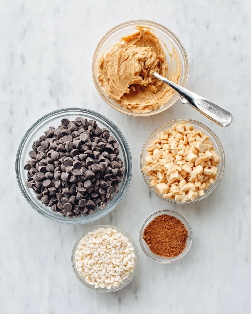 The image shows five clear glass bowls arranged on a white marbled surface. The largest bowl at the bottom left is filled with dark chocolate chips. Directly above it is a medium bowl containing pale, creamy peanut butter, shown inside a silver measuring spoon. To the right of the peanut butter is a smaller bowl of light golden chopped nuts. Above the nuts and to the left is a medium bowl filled with small white rice cereal pieces. At the center bottom right is a tiny bowl with a pinched amount of brown cinnamon powder. photo taken with an iphone --ar 4:5 --v 7