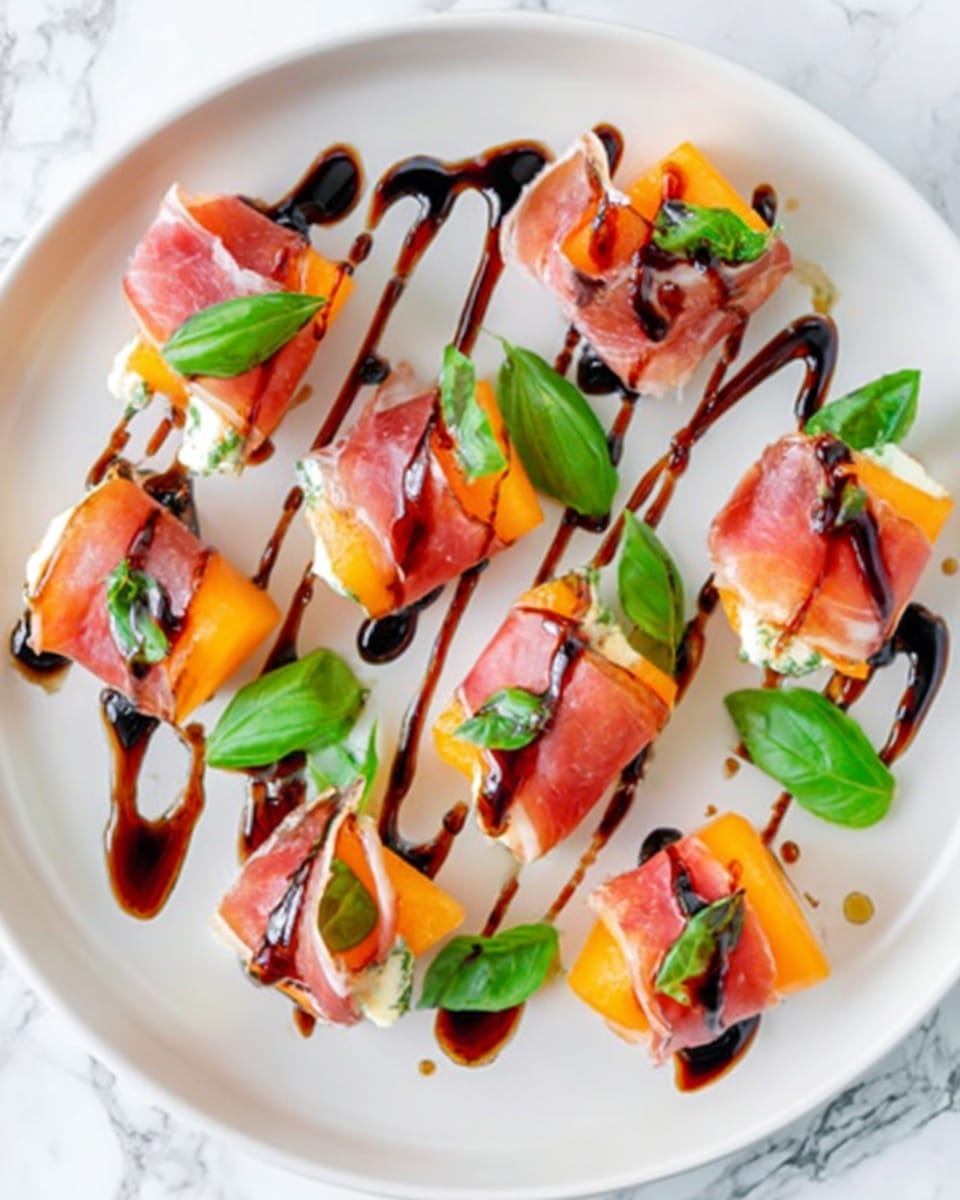 The image shows several small pieces of food arranged on a white plate. Each piece has a thin, orange layer resembling cantaloupe slices, topped with a thin layer of pink prosciutto, both slightly folded and draped. Small fresh green basil leaves are placed on top of each piece, adding a fresh look. Dark brown balsamic glaze is drizzled carefully over the entire plate and food, creating a glossy, shiny texture that contrasts with the colors. The plate sits on a white marbled surface. Photo taken with an iphone --ar 4:5 --v 7
