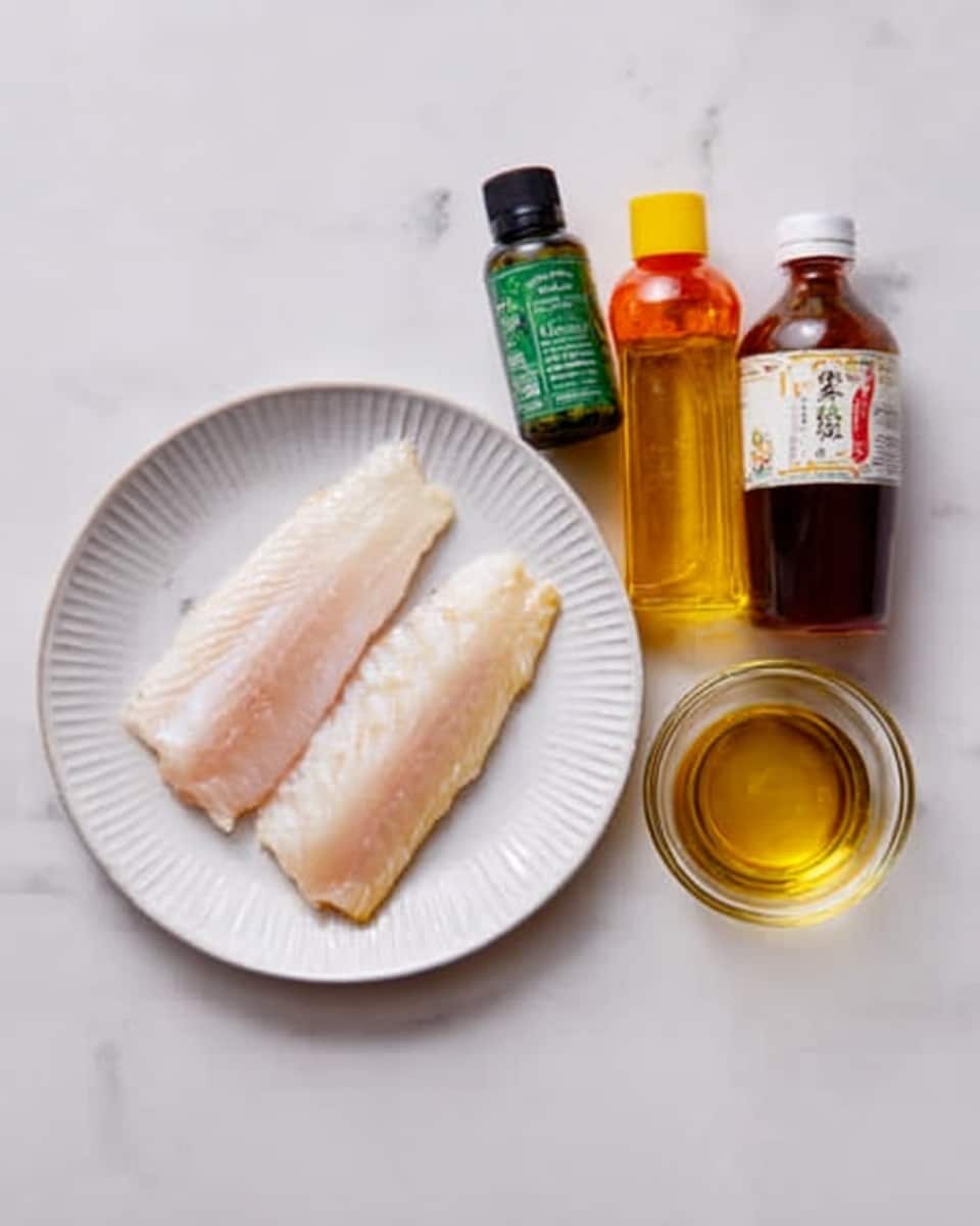 The image shows a white plate with two raw fish fillets, light pinkish-white in color and smooth in texture, placed side by side near the center of the plate. To the right of the plate is a white marbled surface with three small bottles lined up vertically; the first bottle is dark green with a black cap, the second bottle is yellow with an orange cap, and the third bottle is brown with a clear cap. There is also a small clear glass bowl with a golden liquid placed near the top right side of the plate. The whole setup is on a white marbled surface. photo taken with an iphone --ar 4:5 --v 7