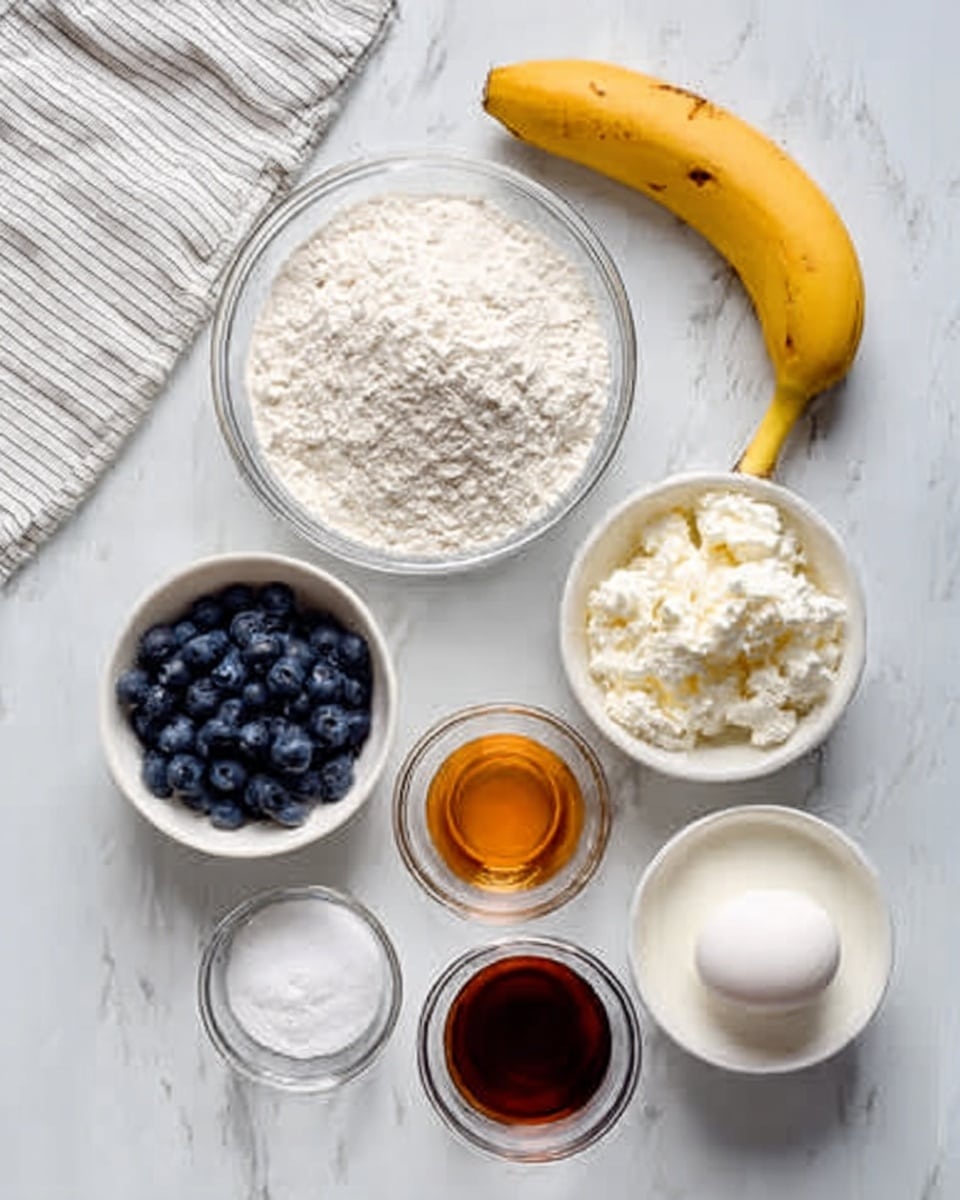 A clear glass bowl holds white flour with a fine texture at the top center of the image. Below it, smaller white bowls contain fresh blue blueberries, white cottage cheese with a soft crumbly texture, and a smooth white liquid that looks like milk. To the left, there is a yellow banana with brown spots resting on a white marbled surface. On the bottom left, a small white bowl shows white granulated sugar and a pinch of white salt. On the bottom right, three small clear bowls hold dark brown vanilla extract, amber-colored honey, and a white egg with a smooth shell. The bowls and items are spaced neatly on a white marbled countertop with a corner of a white and gray-striped cloth visible at the top left. Photo taken with an iphone --ar 4:5 --v 7