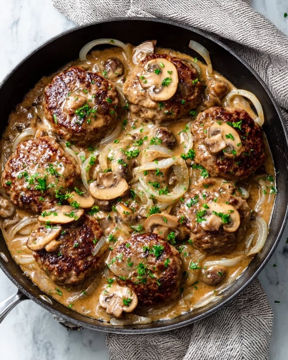 A black skillet filled with several browned meat patties, each topped with creamy light brown mushroom sauce. The sauce has sliced white and light brown mushrooms and thinly sliced onions mixed in. Small green chopped herbs are sprinkled on top, adding color contrast. The skillet rests on a white marbled surface with a folded cloth nearby. The image is clear and detailed, showing the rich texture of the sauce and mushrooms. photo taken with an iphone --ar 4:5 --v 7