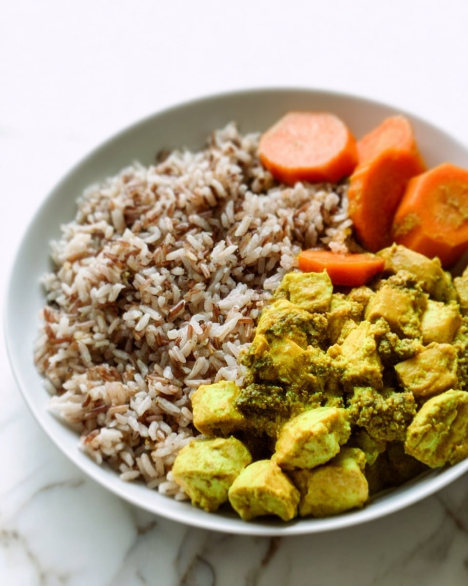 The image shows a white plate on a white marbled surface filled with three food parts. On the left, there is a large portion of mixed brown and white rice with a fluffy texture. On the right side, there are bright yellow and green chunks of curry-coated vegetables or tofu with a slightly rough texture. Above the yellow and green pieces, there are cooked carrot slices with a soft and smooth appearance. The colors create a pleasing contrast between the earthy tones of the rice and the vibrant yellow and green of the curry. Photo taken with an iphone --ar 4:5 --v 7