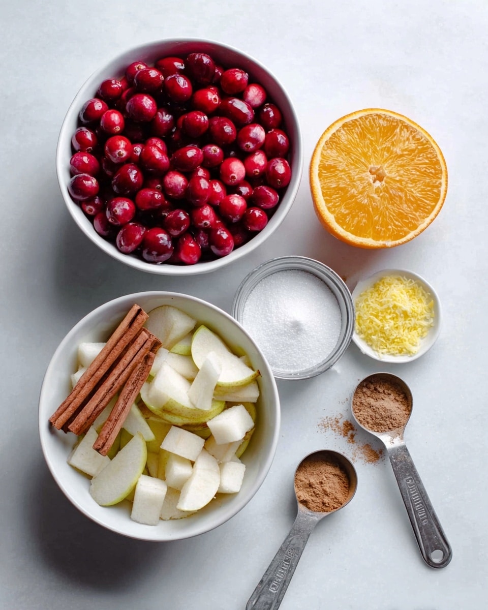A white bowl filled with fresh, bright red cranberries sits on a white marbled surface. Next to it, another white bowl holds sliced white pears with light brown cinnamon sticks and small white cubes. Below these bowls, there is a small white container of fine white sugar, and nearby are two silver measuring spoons filled with light brown spices. To the right, a halved orange with vibrant orange skin and juicy flesh is placed beside a small white bowl of bright yellow zest. The overall scene shows ingredients arranged neatly for preparing a dish, with soft natural light. Photo taken with an iphone --ar 4:5 --v 7
