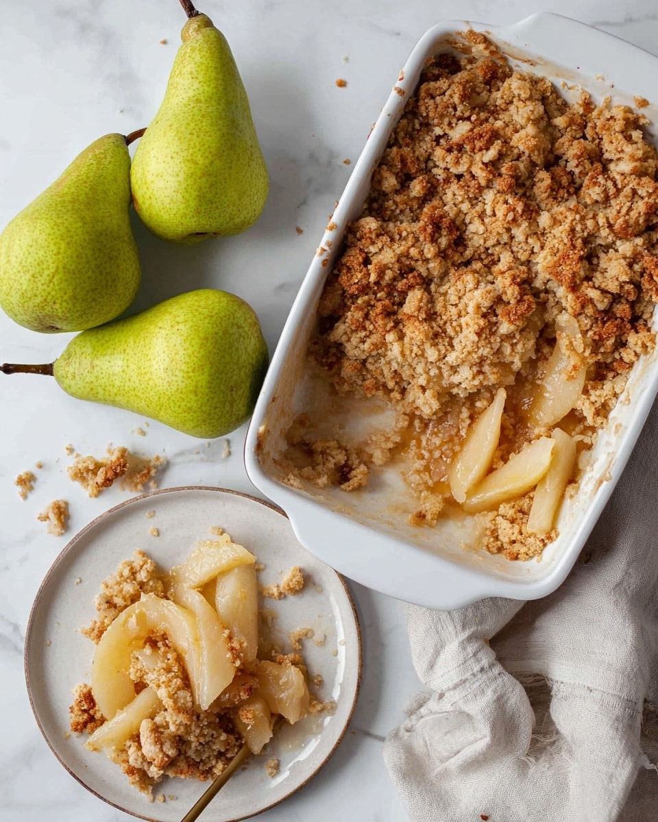 The image shows a white baking dish with a golden brown pear crumble inside, where the top layer is crumbly and textured with small and medium-sized clusters. Beneath the crumble topping, there are slices of soft, light yellow to light brown cooked pears visible. Some crumble bits have fallen outside the dish on a white marbled surface. To the bottom left, a small white plate holds a serving of the crumble with sliced pears and crumble mix layered. Around the dish and plate, there are fresh green pears with smooth skins and brown stems, resting on a light-colored cloth. The scene is bright and clean, with a cozy, homemade feel. photo taken with an iphone --ar 4:5 --v 7