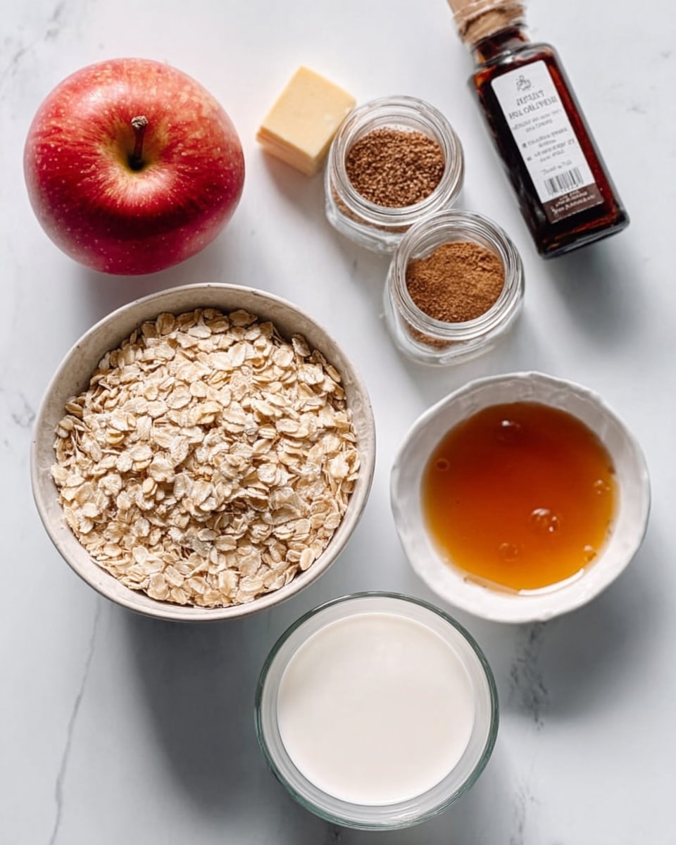 The image shows a white bowl filled with dry rolled oats placed near the center of a white marbled surface. To the right side of the oats is a small white bowl holding amber-colored maple syrup with a smooth texture. Below and to the left of the oats bowl is a clear glass cup filled with white milk. To the top left, there is a whole red apple with a slight shine and a small cube of butter nearby. Two small glass jars with brown lids, containing cinnamon and nutmeg spices, stand behind the bowl of oats. A dark bottle of vanilla extract is placed to the right of the spices. The scene has soft natural light, and the arrangement is neat and clean, with all items clearly visible. Photo taken with an iphone --ar 4:5 --v 7