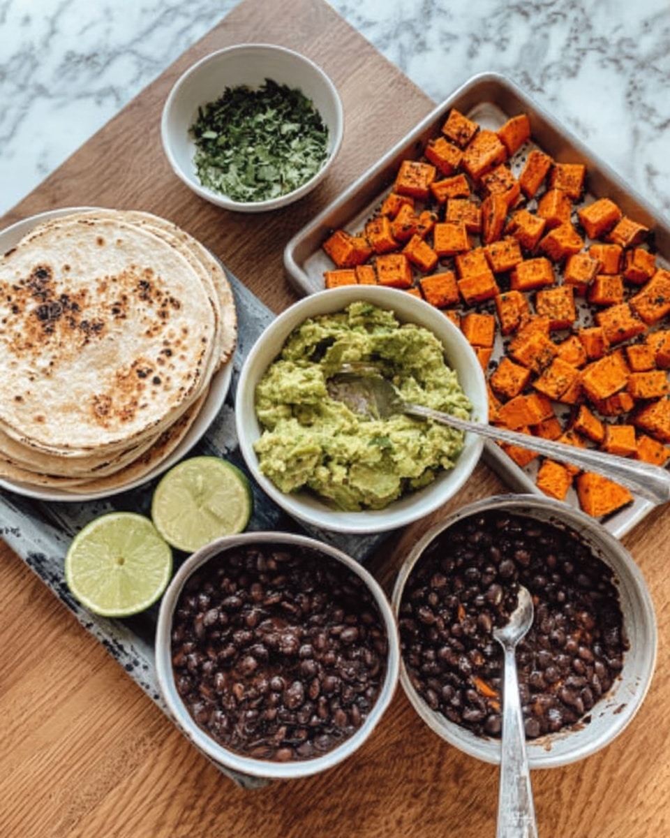 The image shows a white tray with roasted orange sweet potato cubes that have a slightly crispy texture on top. Next to it, there is a white bowl filled with chunky green guacamole, and a spoon is resting inside. Below the guacamole, there is a white bowl holding black beans in dark sauce with a spoon inside. To the left, there is a white plate stacked with soft, lightly toasted tortillas, and a wedge of lime is placed next to the guacamole bowl. In the upper left corner, there is a small white bowl containing a green herb mix. All these dishes are arranged on a wooden table with a white marbled texture in the background. Photo taken with an iphone --ar 4:5 --v 7