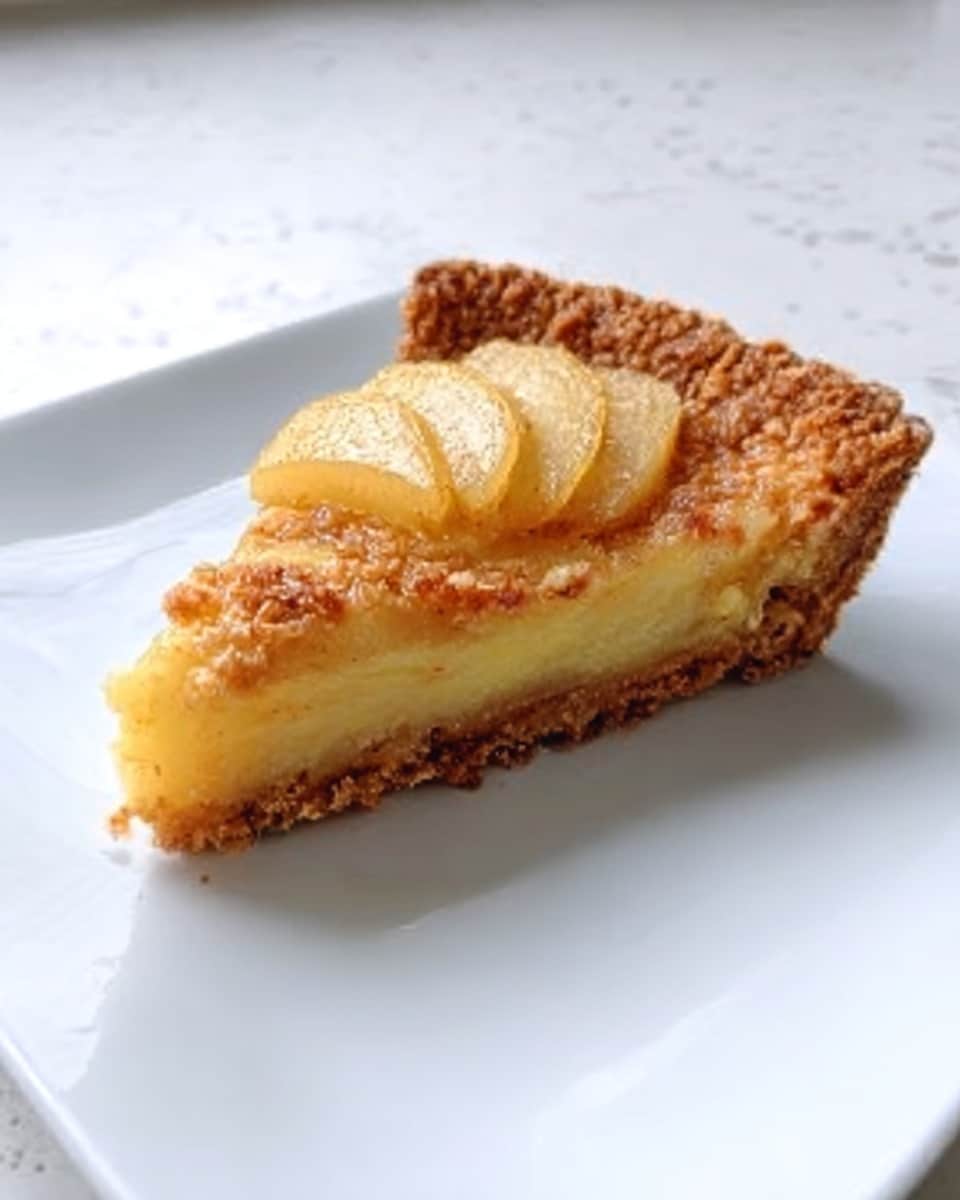 A slice of pie with a golden brown crust that looks crumbly and slightly thick. On top of the pie is a smooth, pale yellow filling with visible pieces of soft pear arranged neatly in a fan shape near the wide end of the slice. The pie sits on a white plate, and the background is a white marbled surface. The photo taken with an iphone --ar 4:5 --v 7