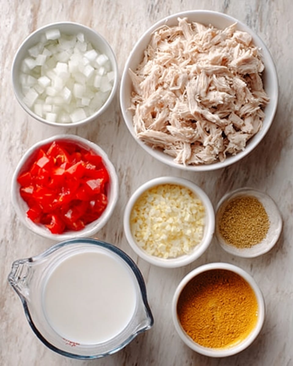 The image shows six small white bowls and a clear measuring cup on a white marbled surface. The largest white bowl holds shredded cooked chicken that is light beige in color and has a soft, fibrous texture. Next to it, a small white bowl contains finely chopped white onions with a glossy, crunchy texture. Another small white bowl has finely chopped red tomatoes, showing a bright, juicy texture. There is a bowl with minced garlic, appearing pale yellow and somewhat moist. Another small white bowl contains ground yellow spices, likely turmeric or curry powder, with a dry, powdery look. The clear measuring cup is filled with white coconut milk, smooth and creamy in texture. photo taken with an iphone --ar 4:5 --v 7