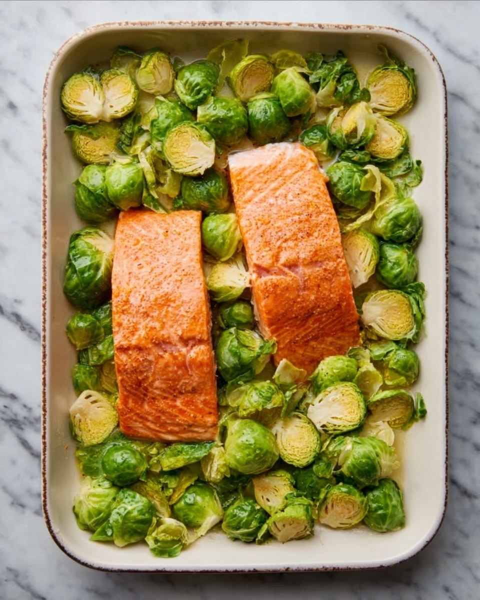 A white rectangular baking dish is filled with two large pieces of cooked salmon placed in the center, showing a pink-orange color with a slightly crisp surface. The salmon is surrounded by bright green Brussels sprouts, some of which have light golden brown edges, indicating they are roasted. The Brussels sprouts are spread evenly around the salmon, covering the entire dish. The dish is set on a white marbled surface. Photo taken with an iphone --ar 4:5 --v 7