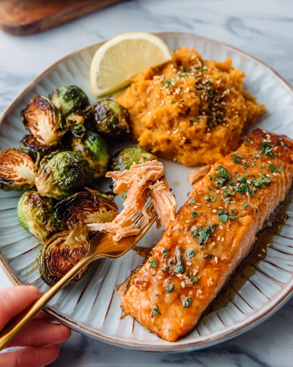 The image shows a white plate with three main layers: on the right side, a thick, shiny piece of cooked salmon with a light glaze and sprinkled green herbs; on the top left, a pile of golden brown mashed sweet potatoes with a slightly rough texture; on the bottom left, crispy roasted Brussels sprouts with charred brown spots and some sesame seeds sprinkled on top, held by a woman's hand holding a gold fork. There is also a lemon wedge placed beside the salmon on the plate. The background is a white marbled surface. Photo taken with an iphone --ar 4:5 --v 7