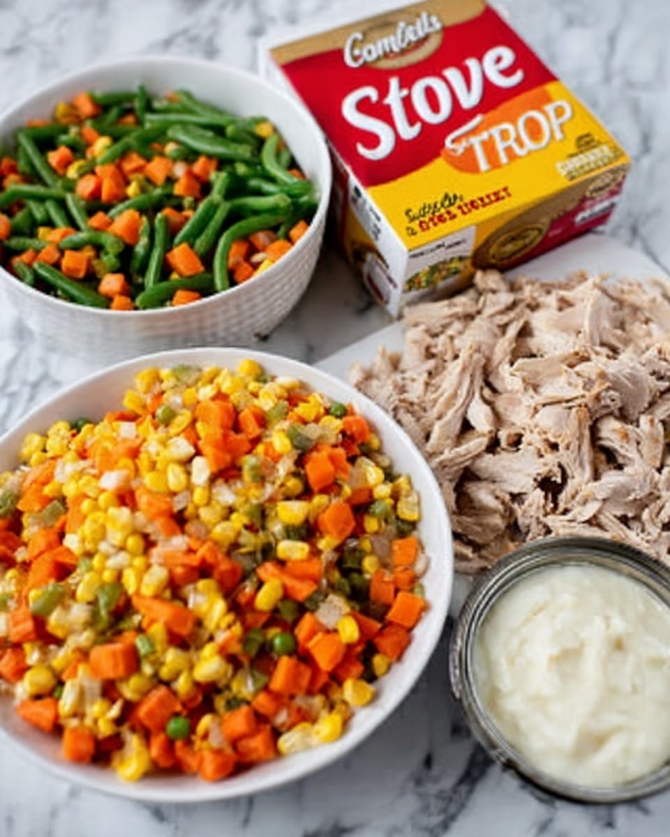 The image shows a white bowl filled with mixed vegetables including bright orange carrots, green beans, and yellow corn, all cut into small pieces. Next to it is a white plate with pieces of cooked chicken that look lightly browned and shredded. Beside the plate is a small white bowl with a creamy white sauce, smooth in texture. In the background, there is a brown and yellow box of Stove Top stuffing mix, red and yellow Campbell’s cream soup can, all placed on a white marbled surface. photo taken with an iphone --ar 4:5 --v 7