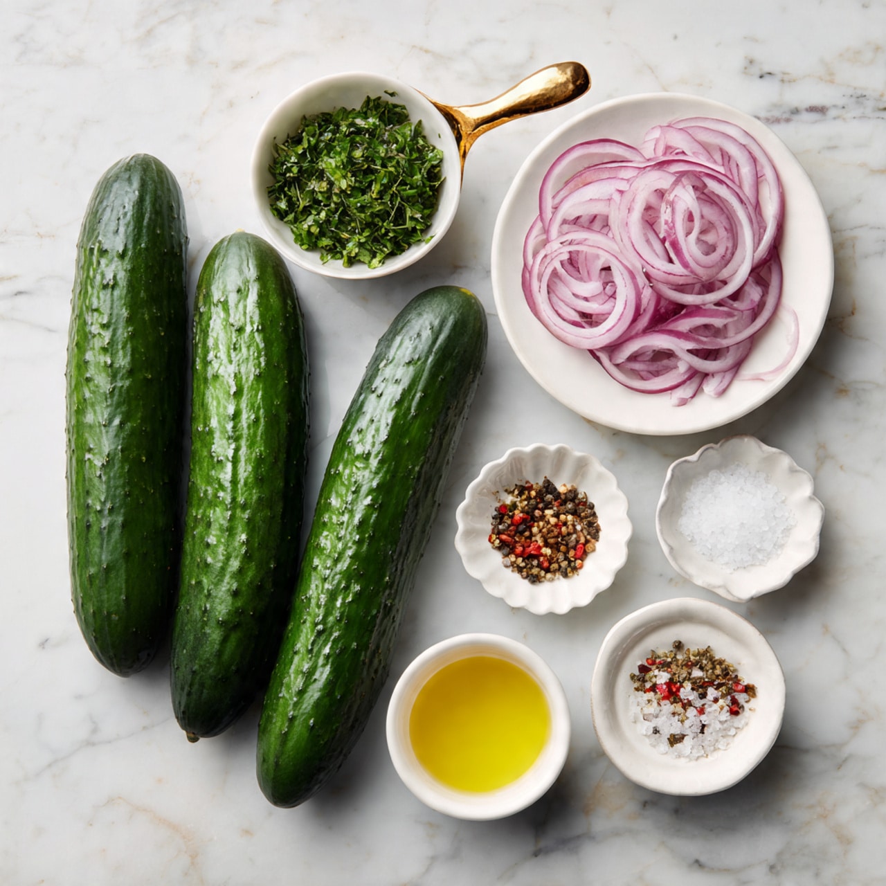 The image shows two long dark green cucumbers lying side by side at the top on a white marbled surface. Below them, in the middle row from left to right, there is a small white bowl with a golden handle filled with chopped green herbs, a white plate holding thin slices of red onion, and a small white scalloped bowl with a clear liquid. At the bottom row from left to right, there is a white bowl filled with a yellow liquid, a small white plate containing a mix of white salt, black pepper, and red chili flakes, and an oval white bowl holding coarse salt. The items are neatly spaced and arranged in three rows. photo taken with an iphone --ar 4:5 --v 7