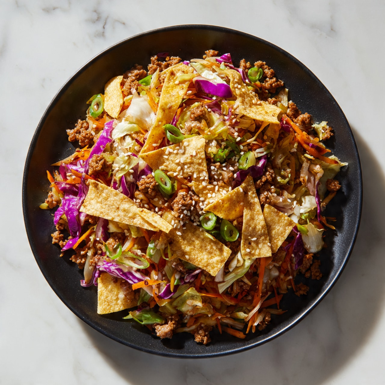 A close-up view of a dish in a dark pan with three main layers: the base is light yellow cooked rice mixed with small pieces of light brown ground meat, the middle layer consists of shredded vegetables including orange carrots, green onions, purple cabbage, and light green cabbage, and the top layer is thin, light beige crispy strips scattered across the dish along with white sesame seeds, all mixed together giving a colorful and textured appearance. The white marbled surface beneath the pan is partly visible on the right side. Photo taken with an iphone --ar 4:5 --v 7