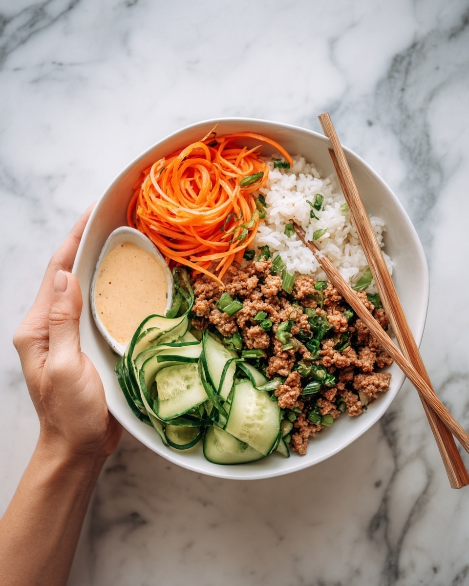 The image shows a white bowl filled with a colorful meal placed on a white marbled surface. Inside the bowl, there is a base layer of white rice at the bottom. On top of the rice, from left to right, there are thin, curly orange carrot strips, light green cucumber slices, and brown cooked minced meat mixed with small green pieces, possibly herbs. In the lower left section of the bowl, a creamy beige sauce is visible next to the carrot strips. The textures vary: the rice looks soft and fluffy, the meat crumbly, and the vegetables fresh and crunchy. A pair of light wooden chopsticks lies next to the bowl, and a woman's hand is holding one chopstick. photo taken with an iphone --ar 4:5 --v 7