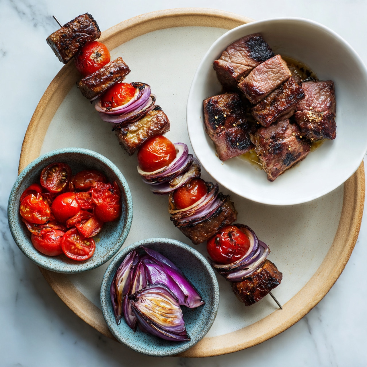A long skewer on a large beige plate holds five sections of grilled lamb chunks alternating with three bright red cherry tomatoes and four layers of purple-red onion slices, all stacked in a neat row. To the right side, a white bowl contains several pieces of marinated cooked lamb with a brown seared outside and pink middle. Above and below this bowl, two smaller grayish-blue speckled bowls hold fresh vegetables – one with vibrant red cherry tomatoes and the other with thick wedges of purple-red onion with white insides. The setting is on a white marbled surface, photo taken with an iphone --ar 4:5 --v 7