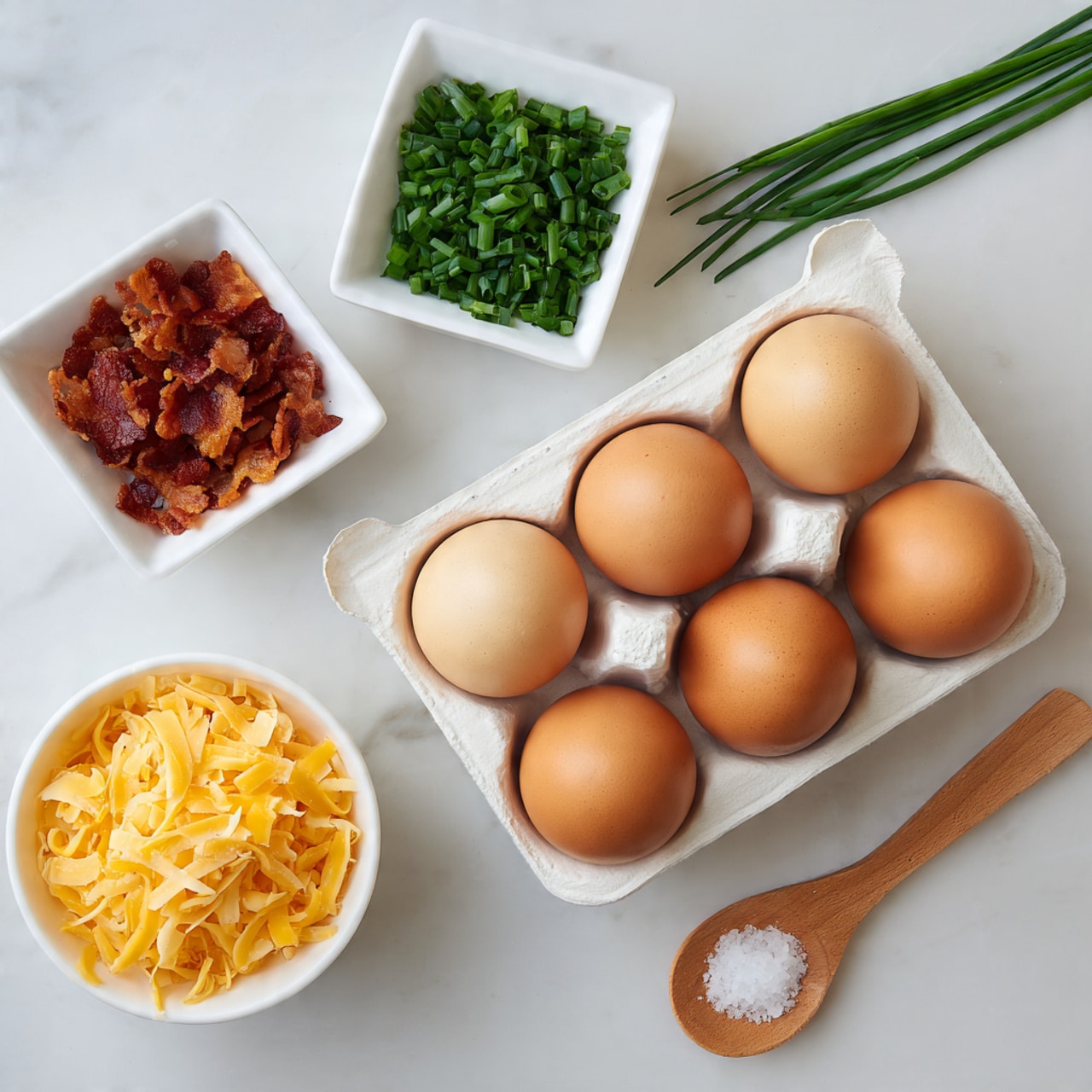 The image shows five brown eggs in a white rectangular egg holder placed near the center of the white marbled surface. Above the eggs, a small white square dish contains chopped green chives, while to the left, another white square dish holds crispy cooked bacon bits. At the bottom left of the image, there is a small white bowl filled with shredded cheddar cheese. A small wooden spoon with white salt sits near the bottom right on the white marbled surface. The overall arrangement is neat, with the different ingredients spaced out evenly, showing their colors and textures clearly. Photo taken with an iphone --ar 4:5 --v 7