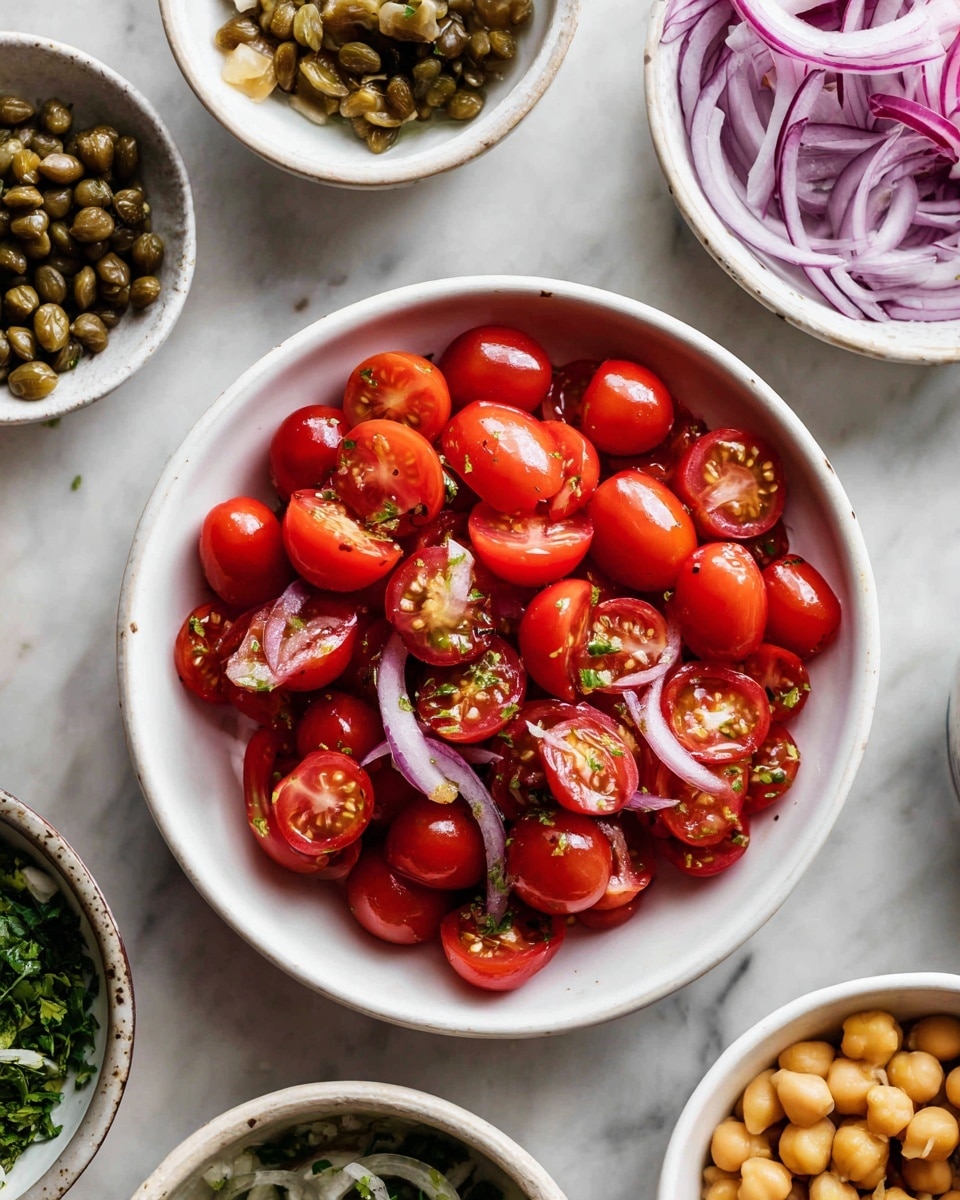 A top view of a white bowl filled with halved red cherry tomatoes shows bright colors and juicy texture. Around the bowl, on a white marbled surface, smaller white bowls contain thinly sliced purple onions, whole golden chickpeas, chopped green herbs, capers, and thin slices of pickled garlic. The arrangement is neat and colorful, with contrasting textures and shapes. photo taken with an iphone --ar 4:5 --v 7