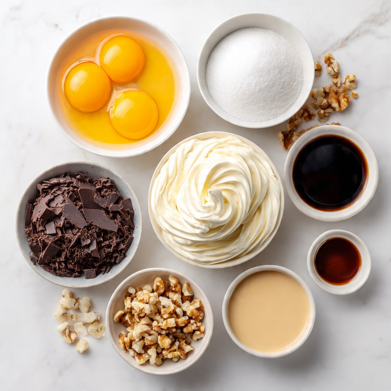 The image shows a white marbled surface with several white bowls, each containing different ingredients arranged neatly. One bowl has three bright orange egg yolks, another bowl holds dark brown chocolate shavings. A third bowl contains thick white cream in soft swirls, while a fourth bowl is filled with white granulated sugar. There is a small bowl with chopped nuts, a bowl with a smooth beige liquid, and a tiny bowl with a dark brown liquid. The bowls are spaced out evenly, creating a clean and organized look. photo taken with an iphone --ar 4:5 --v 7