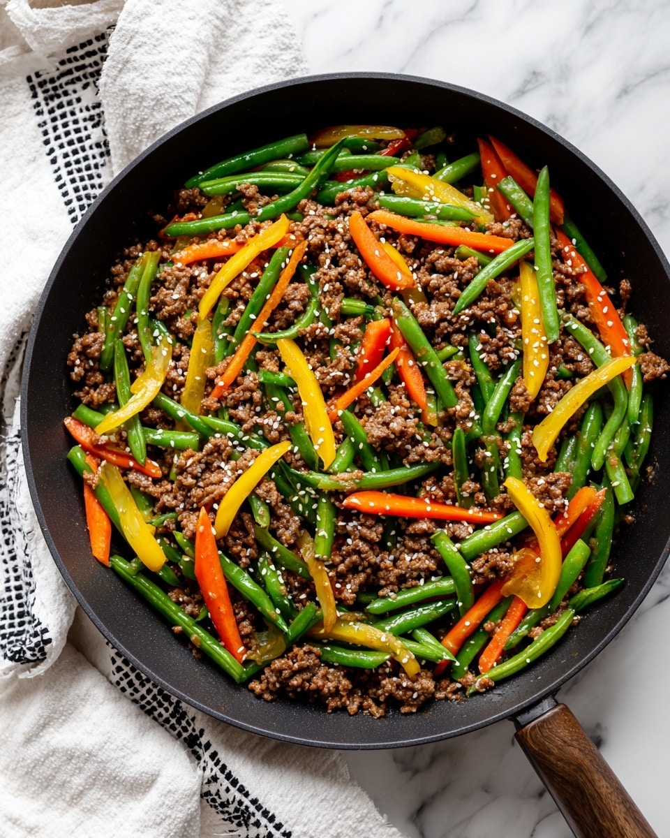 A black skillet filled with a colorful stir-fry dish showing three main layers: the base layer is bright green beans cut into small pieces, the middle layer has thin orange carrot sticks and yellow bell pepper strips, and the top layer is brown cooked ground meat mixed evenly throughout, all sprinkled with small white sesame seeds. The skillet rests on a white marbled surface with parts of a white cloth with black geometric patterns at the lower left. Photo taken with an iphone --ar 4:5 --v 7
