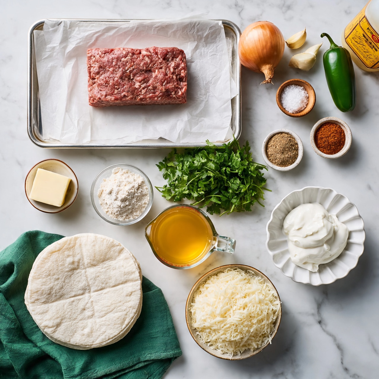 square image The image shows a collection of fresh ingredients neatly arranged on a white marbled surface, ready to make a dish. At the top left, there is a metal tray lined with white parchment paper holding a rectangular block of ground meat. Around it are individual ingredients including a whole onion, three garlic cloves, a green jalapeño, a small wooden bowl of coarse salt, and a bottle with a yellow label. Below, there is a small bowl with a square piece of butter, a small clear bowl with flour, a bunch of fresh green cilantro, and two small spice bowls—one with a brownish powder and another with a reddish powder. A heated golden-yellow broth is in a clear glass measuring cup. At the bottom left, there is a stack of white tortillas resting on a green cloth. To the bottom right, there is a bowl filled with shredded white cheese and a white scalloped bowl with thick white sour cream. Everything is well arranged in a flat lay style, emphasizing the colors and textures of the ingredients. photo taken with an iphone --ar 4:5 --v 7square image