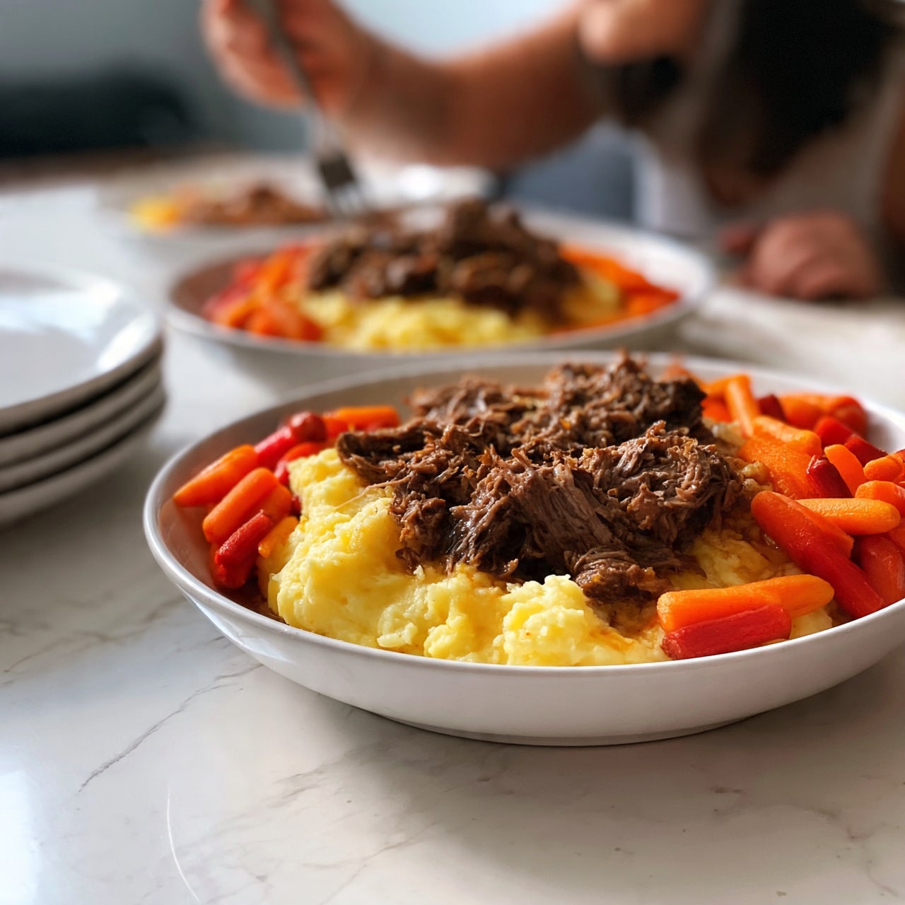 square image The image shows two white bowls filled with a layered meal on a white marbled surface. Each bowl contains soft yellow mashed potatoes as the base layer, topped with shredded brown meat. Around the edges, bright orange and red carrots are placed, adding bright colors to the dish. A woman's hand holding a fork reaches toward the food in the background, and there is a stack of several white plates to the left. The textures are soft mashed potatoes, tender meat with a slight roughness, and smooth carrots. photo taken with an iphone --ar 4:5 --v 7
