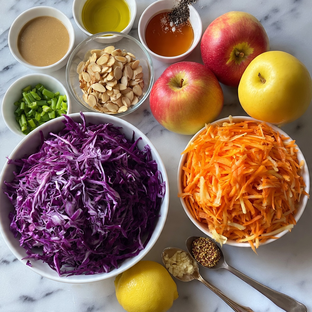 square image A top-down view shows several ingredients laid out on a white marbled surface. There is one large white bowl filled with shredded deep purple cabbage, one white bowl with bright orange shredded carrots, two whole red and yellow apples, a small white bowl of green chopped scallions, and a clear glass bowl filled with light brown sliced almonds. Several small white bowls hold different liquids and spices, including light brown tahini sauce, golden olive oil, amber honey, and black pepper with salt. Two metal spoons hold minced garlic and grainy mustard, and a whole yellow lemon sits near the front. The arrangement is neat and organized, displaying fresh and colorful ingredients ready to be mixed photo taken with an iphone --ar 4:5 --v 7