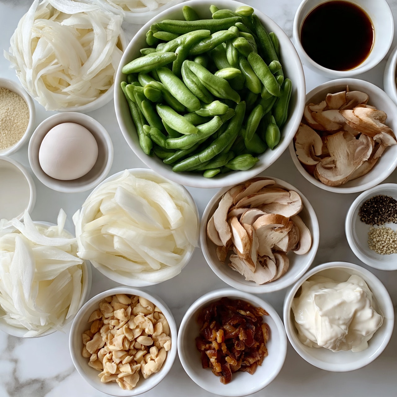 square image A top-down view of many small white bowls arranged neatly on a white marbled surface, each holding different ingredients. The largest bowl near the top center is full of fresh, bright green whole beans with a smooth texture. Around it are bowls mostly filled with thin, white creamy slices of onion, light brown sliced mushrooms with soft edges, and light beige chopped nuts. Smaller bowls hold an off-white powder, a raw egg, small piles of black and white pepper, some sticky bacon pieces, and a dollop of thick white cream. A small white bowl near the top right contains dark brown liquid sauce. The colors range from green and brown shades to whites and creams, displaying a natural and simple arrangement. photo taken with an iphone --ar 4:5 --v 7