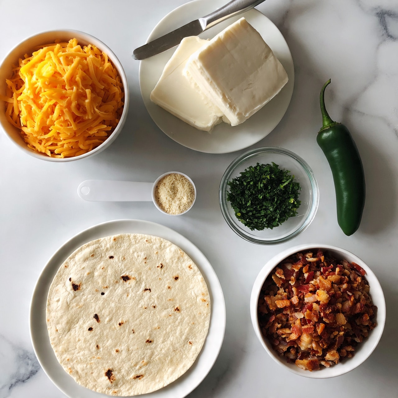 square image The image shows several white bowls and a white plate arranged on a white marbled surface. At the bottom left, a white plate holds a round, flat tortilla with small dark spots. Above it to the left, a white bowl filled with shredded orange cheddar cheese. Next to the cheese, a white plate holds two blocks of soft white cheese with a silver knife resting on it. Below the cheese plate, a white measuring spoon is filled with a light-colored powder, likely seasoning. To the right of the powder, a clear glass bowl contains chopped green herbs, and next to it stands a whole green jalapeno pepper. At the bottom right, a white bowl is filled with finely chopped cooked bacon bits. Photo taken with an iphone --ar 4:5 --v 7