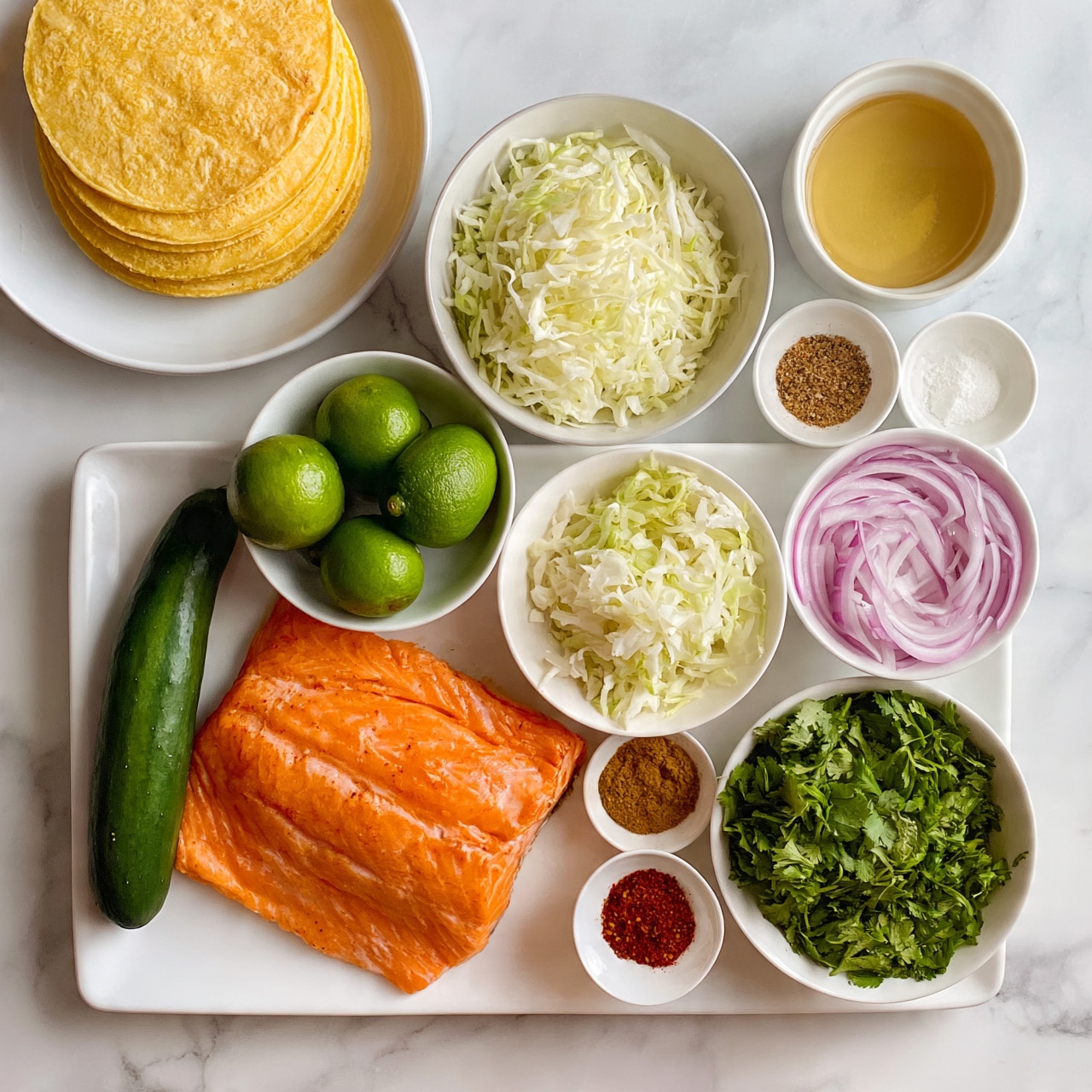square image The image shows several white dishes and bowls arranged neatly on a white marbled surface. There is a large white rectangular plate holding a bright orange salmon fillet on the left bottom side. Around it, small white bowls contain various ingredients: a bowl of finely shredded white cabbage, whole green limes, a bowl of clear golden liquid, a bowl of mixed fresh green herbs including cilantro, a bowl of thinly sliced red onions, and smaller bowls with different powders and spices in brown, red, and white colors. A white plate holds soft yellow corn tortillas stacked on the top left. A whole green cucumber is placed next to the salmon plate. The image has a clean, fresh, and colorful look. Photo taken with an iphone --ar 4:5 --v 7